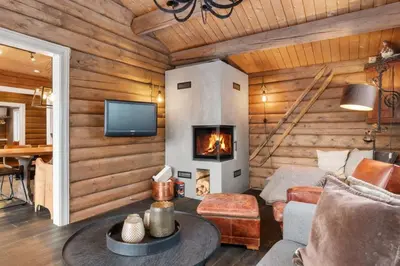 a living room with a fireplace in a log cabin at Trysilfjell 636 by Vacation Trysil in Trysil