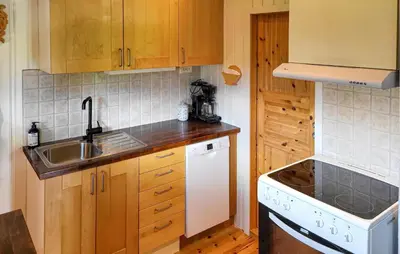 a kitchen with wooden cabinets and a sink at 2 Bedroom Nice Home In Hafjell in Hafjell