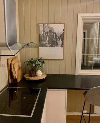 a kitchen with a black counter with a picture on the wall at Trivelig lite hus in Lii