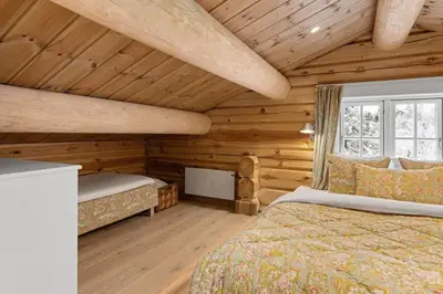 a bedroom with two beds in a log cabin at Trysilfjell 25 by Vacation Trysil in Trysil