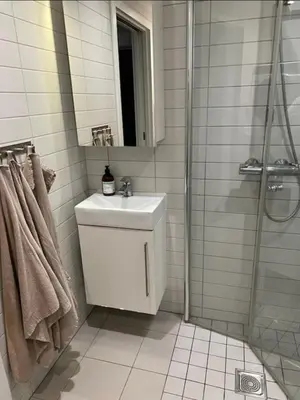 a white bathroom with a sink and a shower at Lys leilighet på Kaldnes in Lii