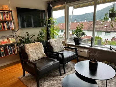 a living room with two chairs and a table and a window at Family-friendly townhouse on Landås in Lii