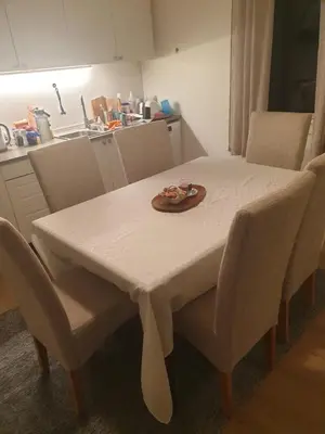 a white table with chairs and a plate of food on it at Holiday Home Garnås in Nesbyen