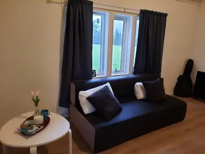 a living room with a black couch and a table at Holiday Home Garnås in Nesbyen