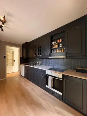 a kitchen with black cabinets and a wooden floor at Martine's home in Lii
