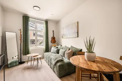 a living room with a green couch and a table at City Apartment I Cozy with Perfect Location in Bergen