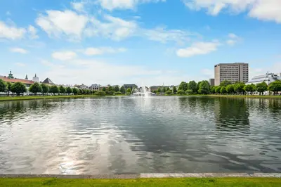 a pond with a fountain in the middle of a city at City Apartment I Cozy with Perfect Location in Bergen
