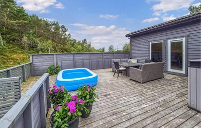 a deck with a table and a blue ottoman at 3 Bedroom Gorgeous Home In Kolbeinsvik in Kolbeinsvik