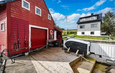 a red barn with a wooden deck next to a building at Amazing Home In Rong With Ethernet Internet in Rong