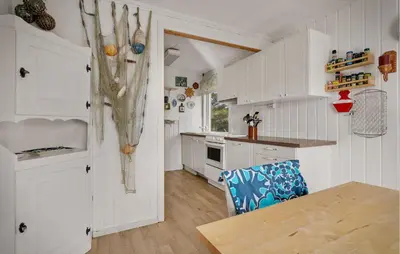 a kitchen with white cabinets and a table and a chair at Amazing Home In Rong With Ethernet Internet in Rong