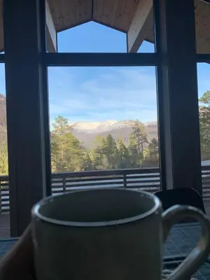 a coffee cup sitting on a table in front of a window at Moderne og romslig familiehytte i Stryn in Stryn