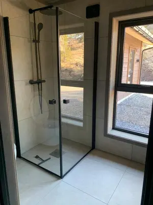 a glass shower in a bathroom with a window at Moderne og romslig familiehytte i Stryn in Stryn