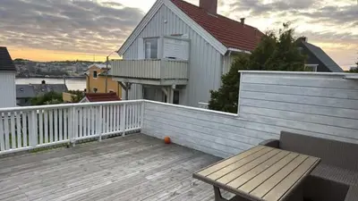 a wooden deck with a bench on top of a house at KSU Topleiligheten in Kristiansund