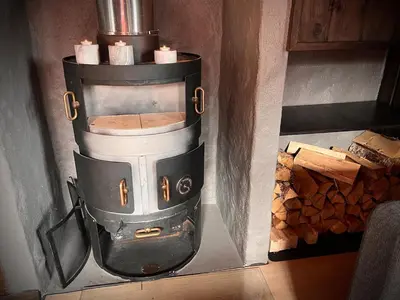 a stove in a room with a pile of wood at Hytte på Norefjell in Surteberg