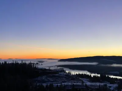 a view of a foggy valley at sunset with the sun setting at MYLLA - New cabin - Sauna - Hike - Bike - Canoe- Fishing in Jevnaker