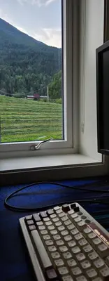 a computer keyboard sitting in front of a window at Lakeside apartment in Stryn