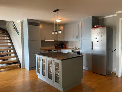 a kitchen with white cabinets and a refrigerator at Stor Toppleilighet I Sentrum in Beitostøl