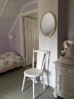 a room with a chair and a mirror and a bed at Welcome to Dalborg, only 1,5 hours from Oslo