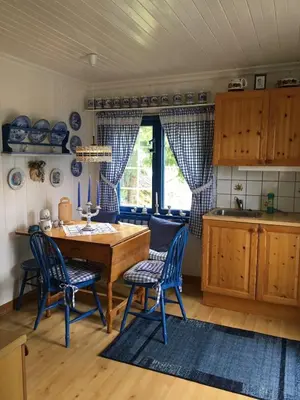 a kitchen with a wooden table and blue chairs at Welcome to Dalborg, only 1,5 hours from Oslo