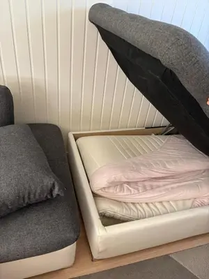 a bed sitting on a wooden floor next to a couch at Apartment in Bergen in Bergen
