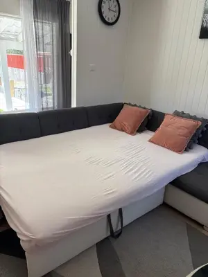 a large bed with two pillows and a clock on the wall at Apartment in Bergen in Bergen