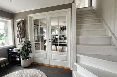 a hallway with a white door and stairs at Nordic Villa Retreat in Ålesund