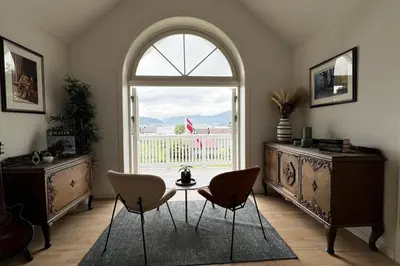 a living room with a table and chairs and a window at Nordic Villa Retreat in Ålesund