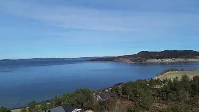 a view of a large body of water at Cabin at the end of Skardsøya towards the sea - boat in Bukta
