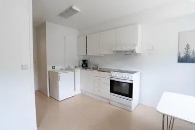 a white kitchen with a stove and a refrigerator at Standard Hytte in Fjæra