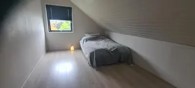 a small bedroom with a bed and a window at House close to the beach with a view! in Ålesund