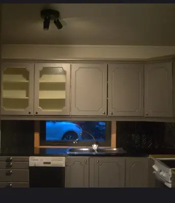 a kitchen with white cabinets and a sink and a window at House close to the beach with a view! in Ålesund