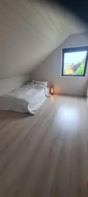 a bedroom with a bed and a window in a attic at House close to the beach with a view! in Ålesund