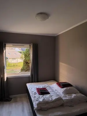 a small bedroom with a bed with a window at House in Nordfjord, with 4 bedrooms in Nordfjordeid