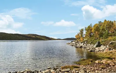 a river with rocks and trees on the shore at Amazing Home In Tunhovd With Sauna in Tunhovd