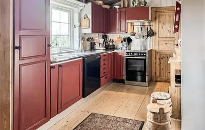 a kitchen with wooden floors and red cabinets at Amazing Home In Tunhovd With Sauna in Tunhovd