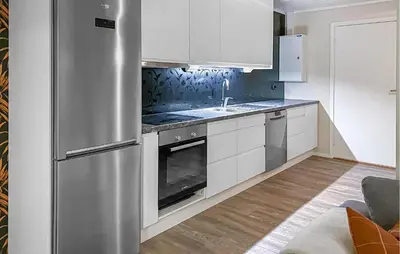 a kitchen with white cabinets and a stainless steel refrigerator at Amazing Apartment In Bjorli With Sauna in Bjorli