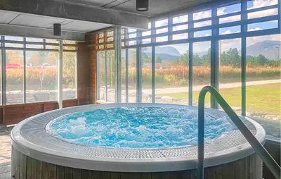 a hot tub in a room with a large window at Amazing Apartment In Bjorli With Sauna in Bjorli
