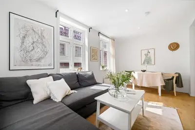 a living room with a couch and a table at Modern apartment near bryggen - classic architecture in Bergen