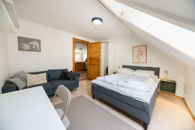 a bedroom with a bed and a couch at 3BR loft-apartment near Downtown & Ocean in Bergen