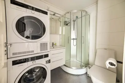 a bathroom with a washing machine and a shower at 3BR loft-apartment near Downtown & Ocean in Bergen