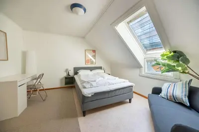 a attic bedroom with a bed and a window at 3BR loft-apartment near Downtown & Ocean in Bergen