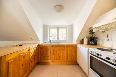 a kitchen with wooden cabinets and a sink at 3BR loft-apartment near Downtown & Ocean in Bergen