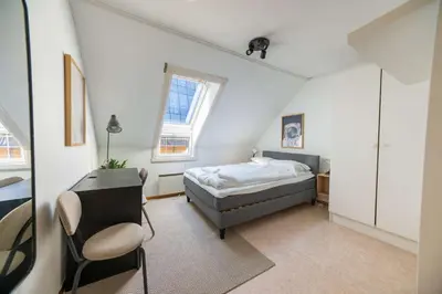 a bedroom with a bed and a desk and a chair at 3BR loft-apartment near Downtown & Ocean in Bergen