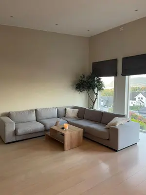 a living room with a couch and a coffee table at Semi-detached house with lovely views of the city fjord in Askøy