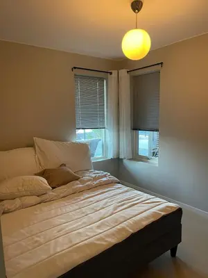a bedroom with a bed with a light on the ceiling at Semi-detached house with lovely views of the city fjord in Askøy