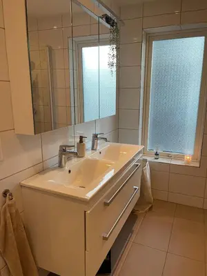 a bathroom with a sink and a mirror and a window at Semi-detached house with lovely views of the city fjord in Askøy