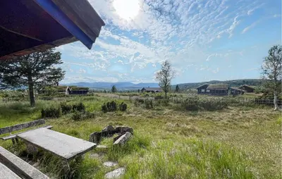 a wooden bench sitting in a field of grass at Beautiful Home In Røn With Sauna in Ron