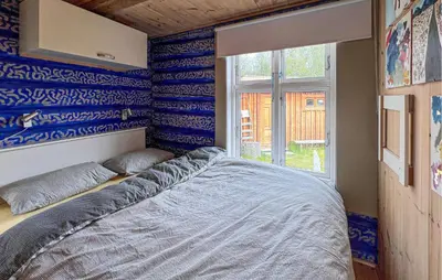 a bedroom with blue and white walls and a bed at Beautiful Home In Røn With Sauna in Ron