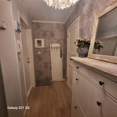 a hallway with a mirror and a room with a refrigerator at Quiet home with garden in Bergen
