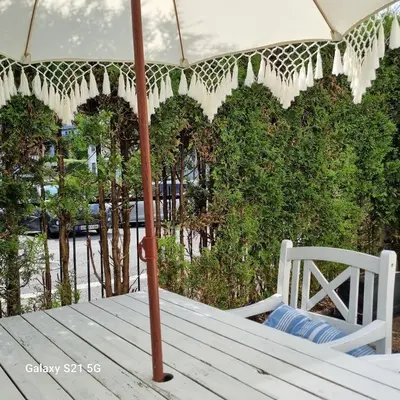 a white table with an umbrella and a chair at Quiet home with garden in Bergen